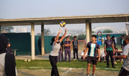 Students play volleyball on the outdoor court.