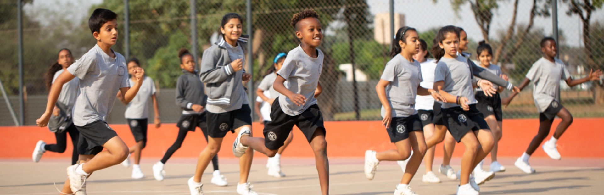 Students engaged in outdoor sports, demonstrating teamwork and energy on the field