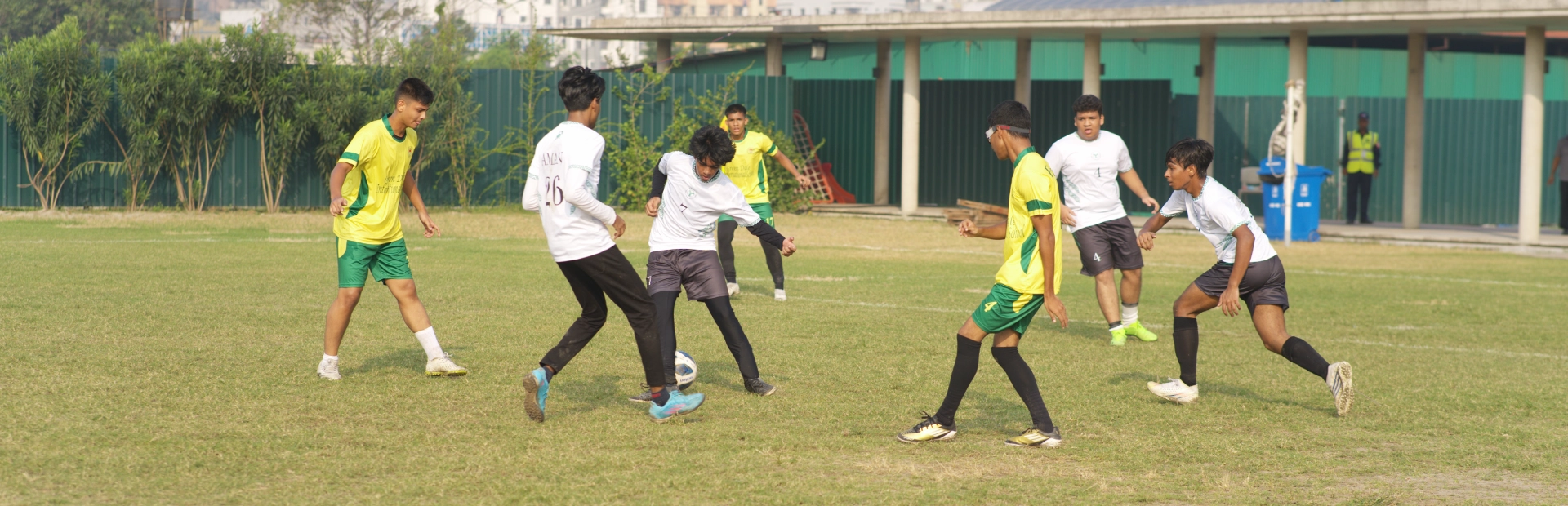 A group of students playing a football match on the field.