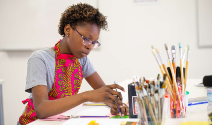 A student painting inside an art classroom at AKA Maputo.