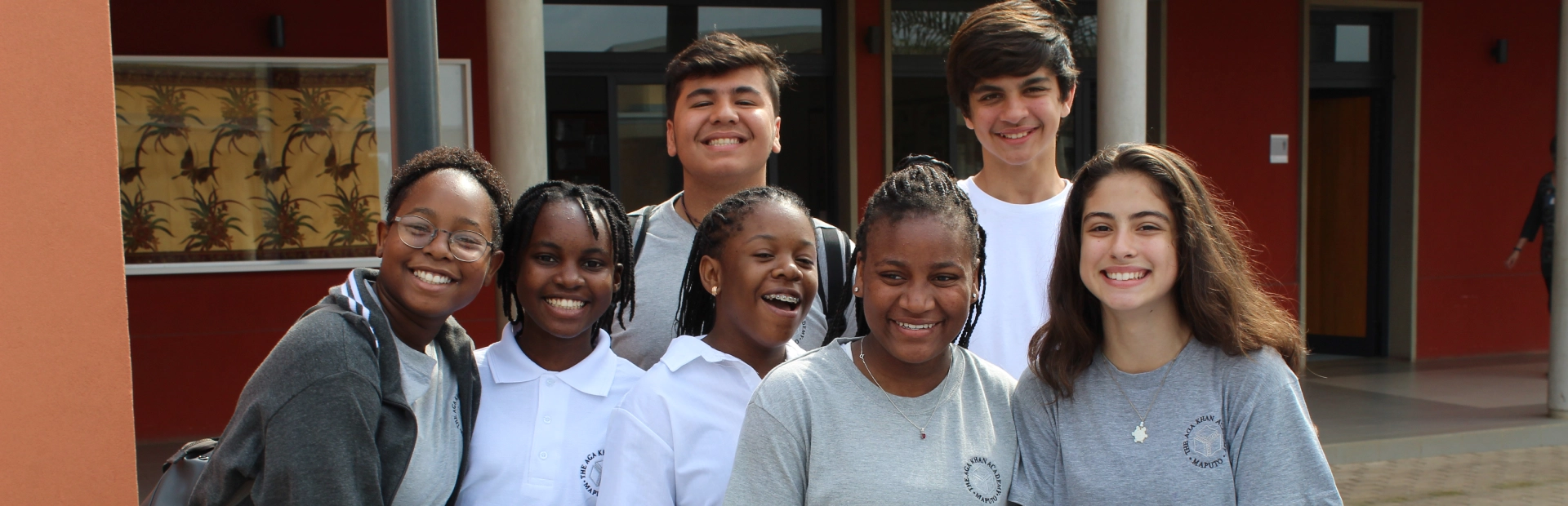 Students standing outside their respective classrooms, posing for the camera.