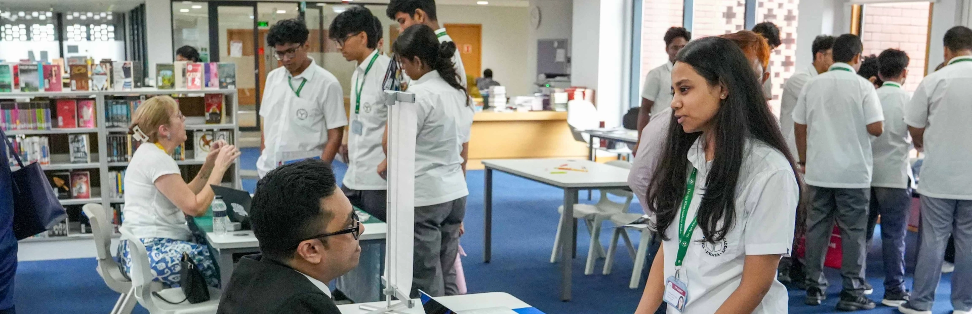 Students speak with university representatives during a university fair at AKA Dhaka.